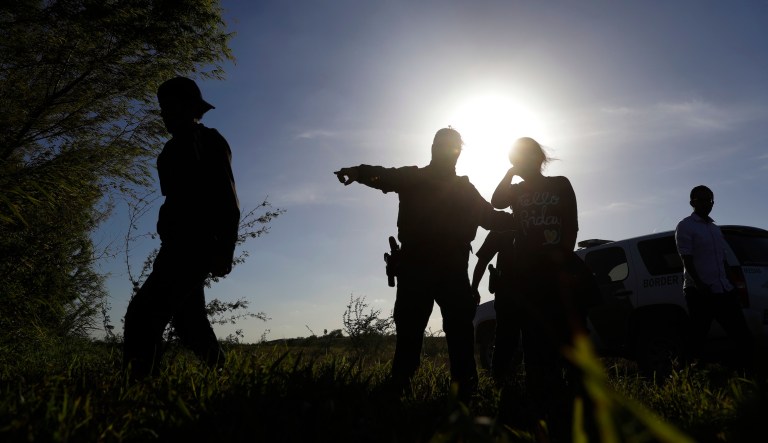 In this Aug. 11, 2017, photo U.S. Customs and Border Patrol agents pick up immigrants suspected of crossing into the United States illegally along the Rio Grande near Granjeno, Texas.