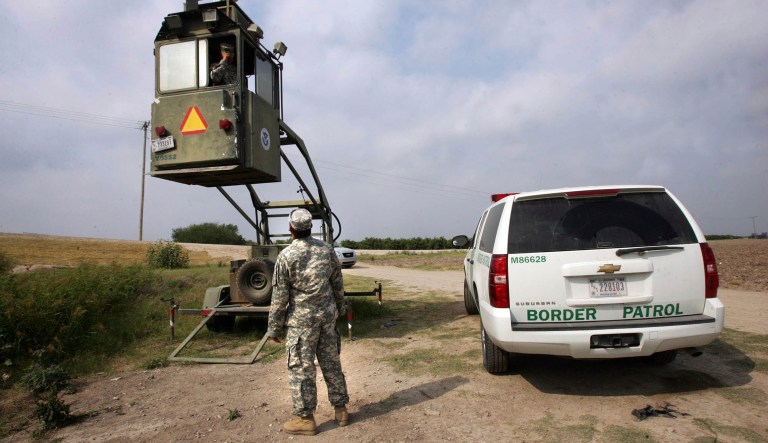 FILE - In this April 19, 2011 file photo, a member of the U.S. National Guard checks on his colleague inside a Border Patrol Skybox near the Hidalgo International Bridge in Hidalgo, Texas. National Guard members along the Texas-Mexico border assist Border Patrol by surveying the terrain from the tower. The U.S. National Guard faces a vastly different landscape than it did on its last two deployments to the Mexican border but its role is shaping up much the same: moving Border Patrol agents from behind-the-scenes jobs to making arrests on the front lines. The Guard was assigned to observation posts some distance from the border for safety reasons, using binoculars and other gear to spot people crossing. Richard Barlow, then a top Border Patrol official in San Diego, said their success as lookouts varied because they were unarmed and needed protection in more dangerous areas.