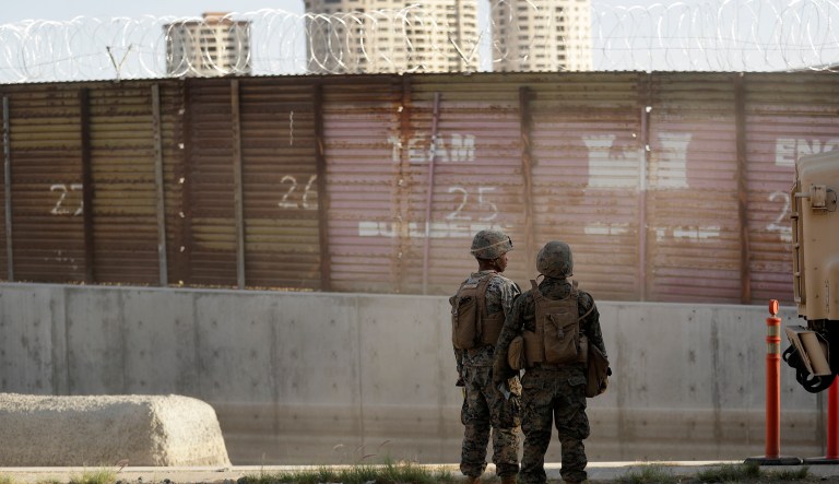 Marines look on during work to fortify the border structure that separates Tijuana, Mexico, behind, and San Diego, near the San Ysidro Port of Entry, Friday, Nov. 9, 2018, in San Diego. The military along the California border with Mexico worked Friday to fortify the border structure, including adding concertina wire to the tops of the rusting wall of corrugated metal. The military is expected to have the vast majority of the more than 7,000 troops planned for the mission along the border deployed by Monday, and that number could grow.