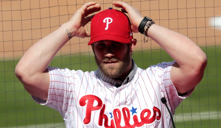 Bryce Harper adjust his cap as he's introduced as a Philadelphia Phillies player during a news conference at the team's spring training baseball facility, Saturday, March 2, 2019, in Clearwater, Fla. Harper and the Phillies agreed to a $330 million, 13-year contract, the largest deal in baseball history. 
