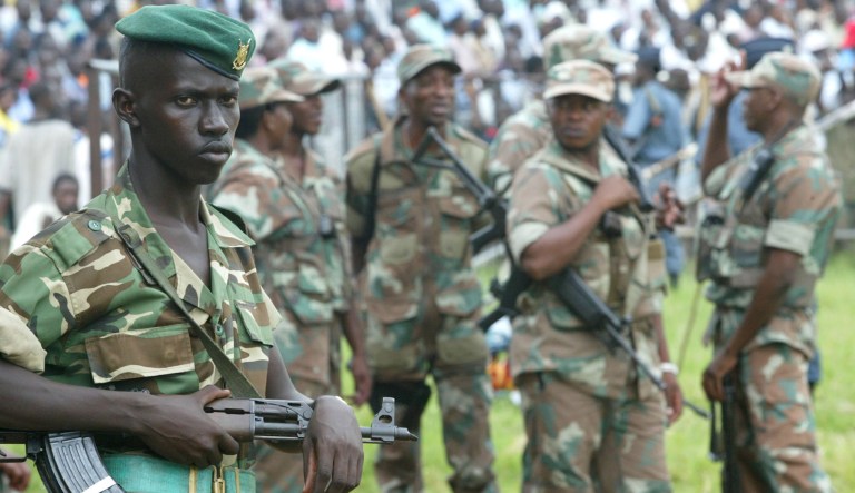 A Burundian soldier stand in front of a group of South African soldiers during Workers Day celebrations Thursday, May 1, 2003 at the Bujumbura stadium , Burundi. South African peacekeeping troops have arrived in Burundi over the past week as fighting continue in the country's 9 1/2-year civil war.