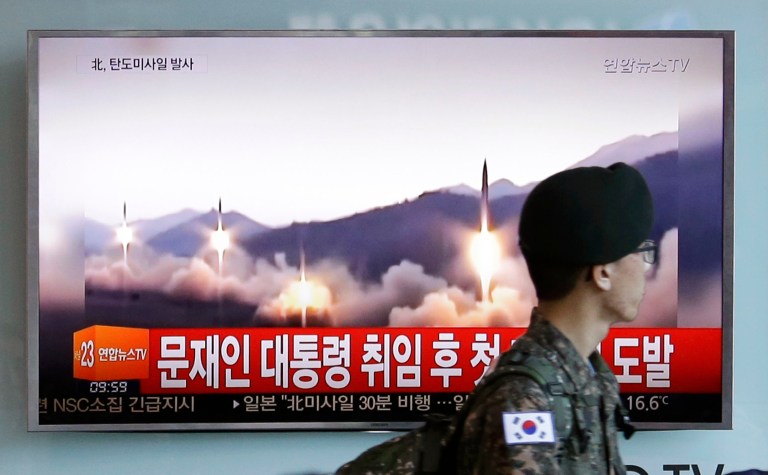 A South Korean army soldier walks by a TV news program showing a file image of missiles being test-launched by North Korea, at the Seoul Railway Station in Seoul, South Korea. (AP Photo/Ahn Young-joon)