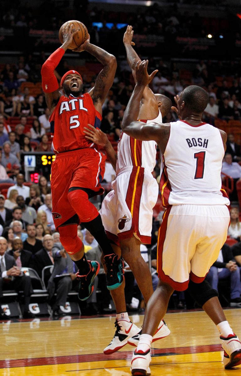   Atlanta Hawks' Josh Smith (5) prepares to shoot over Miami Heat's Shane Battier, center, and Chris Bosh in the first half of an NBA basketball game, Monday, Dec, 10, 2012, in Miami. (AP Photo/Alan Diaz)  