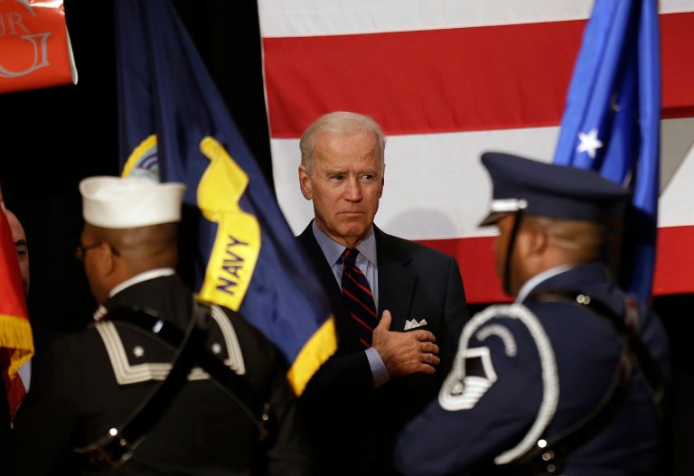 Vice President Biden stands with his hand over his heart as a military color guard passes by during a naturalization ceremony at the Martin Luther King Jr. Center in Atlanta on Thursday. (AP Photo/John Bazemore)
