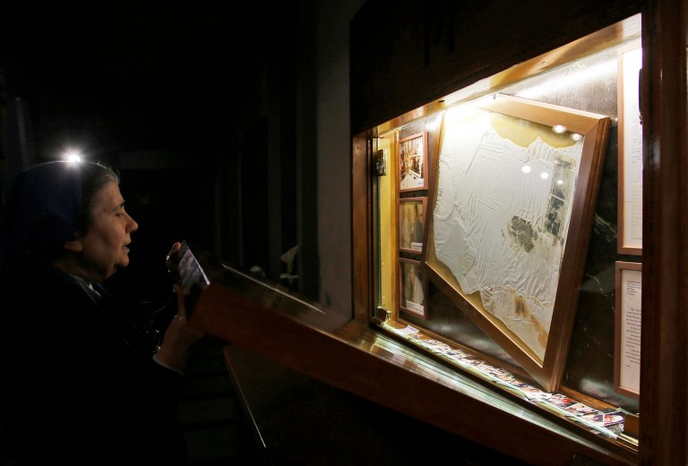 Sister Marisa from the Daughters of Charity closes the altar Thursday, April 10, 2014 where the bloodstained undershirt worn by Pope John Paul II during the assassination attempt on May, 13, 1981 is kept, in Rome.  (AP Photo/Gregorio Borgia)