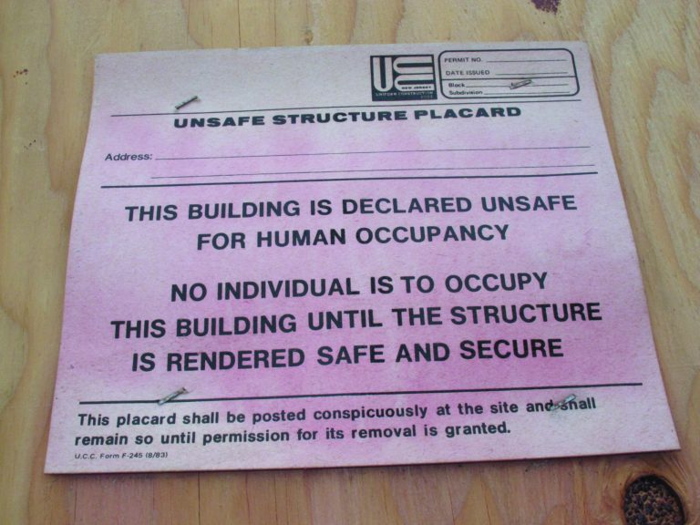 This Jan. 15, 2013 photo shows a faded condemnation notice tacked onto plywood protecting a damaged business in Sea Bright N.J. The town's entire business district was wiped out by Superstorm Sandy (four shops have since re-opened) and 75 percent of residents are still homeless. Yet Sea Bright is determined to rebuild as a debate rages on whether to restore shore communities to their pre-storm condition, or buy out properties in flood-prone areas and depopulate them. (AP Photo/Wayne Parry)