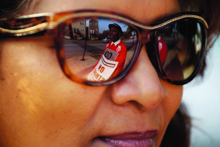 Michael Grant, a parent of a Chicago public school student, is reflected in the glasses of teacher Yasman Vaughn as a handful of teachers picket outside Shoop Elementary School in Chicago, Monday, Sept. 17, 2012, as a strike by Chicago Teachers Union members heads into its second week. Mayor Rahm Emanuel said he will seek a court order to force the city's teachers back into the classroom. (AP Photo/M. Spencer Green)