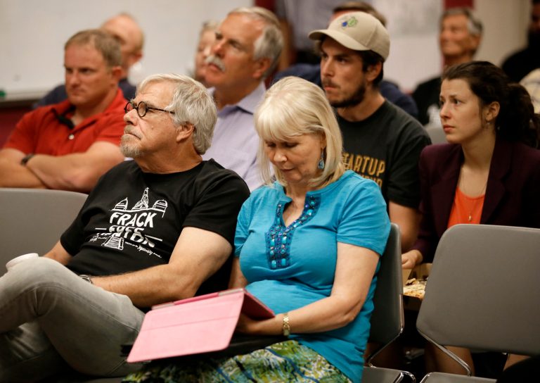 Area residents and registered speakers watch proceedings on a television screen from one of the three overflow rooms as others wait their turn to address the city council during a public hearing, Tuesday, July 15, 2014, in Denton, Texas. The North Texas city could become the first in the state to ban hydraulic fracturing if city leaders approve a citizen-led petition to outlaw the drilling method. (AP Photo/Tony Gutierrez)