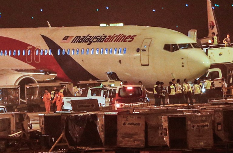 Ground crew check the Malaysia Airlines flight MH192 bound for Bangalore that turned back towards and parked at Kuala Lumpur International Airport in Sepang, Malaysia, Monday, April 21, 2014, after its right landing gear malfunctioned upon takeoff. The airline says Flight 192 carrying 166 people landed safely at the Kuala Lumpur International Airport early Monday, four hours after it departed. (AP Photo/Vincent Thian)