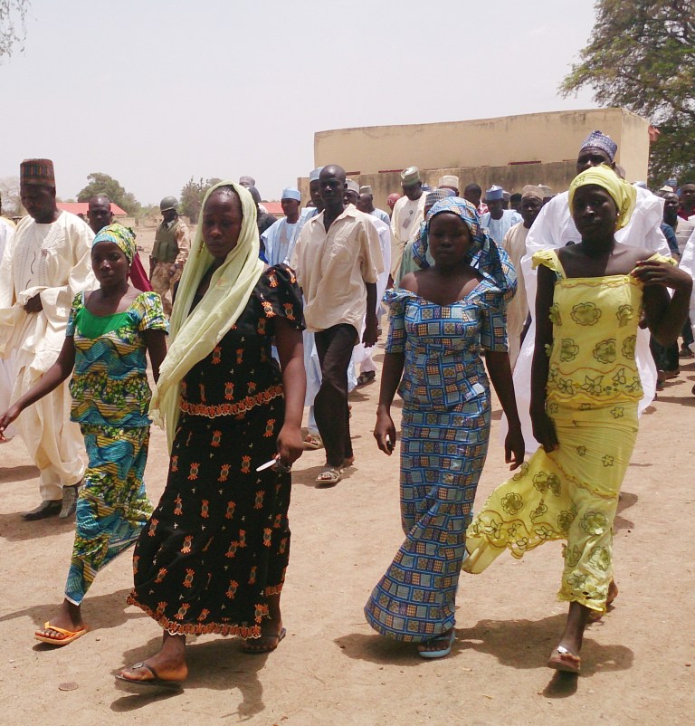 FILE - In this Monday April 21, 2014 file photo, four female students of government secondary school Chibok, who were abducted by gunmen and reunited with their families walk in Chibok, Nigeria. The number of kidnapped schoolgirls missing in Nigeria has risen to 276, up by more than 30 from a previous estimate, police said, adding that the actual number abducted by Islamic extremists on April 14 was more than 300. Police Commissioner Tanko Lawan said the number of girls and young women who have escaped also has risen, to 53. (AP Photo/ Haruna Umar, File)