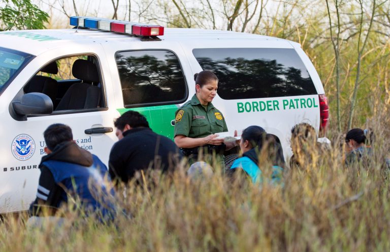 A U.S. Border Patrol agent speaks to suspected illegal immigrants near the U.S.-Mexico border in McAllen, Texas, on Dec. 21. President-elect Trump's incoming Cabinet is a collection of people with varying views on how to solve the immigration crisis. (Eddie Seal/Bloomberg)