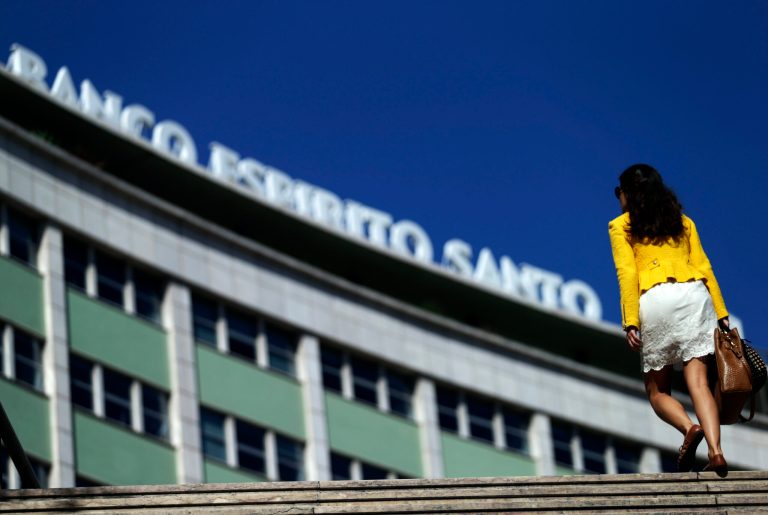 A woman exits a subway station next to a Portuguese bank Banco Espirito Santo's offices building, in Lisbon, Monday, Aug. 4, 2014. Portugal's biggest banking scandal, which compelled authorities Sunday to put up euro 4.9 billion ($6.6 billion) to prevent the collapse of ailing Banco Espirito Santo, raised key questions about how regulators were apparently hoodwinked and focused minds on the European banking system stress tests, whose results are due in October. (AP Photo/Francisco Seco)