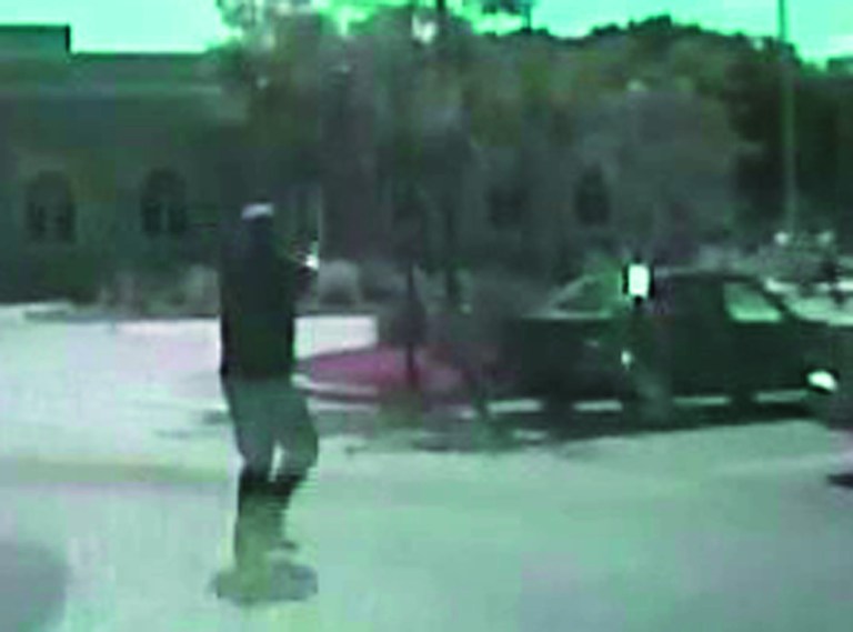 In this image taken from a Aug. 5, 2012 video from Oak Creek Police Lt. Brian Murphy's squad car camera, Lt. Murphy, the first officer on the scene, exchanges fire in the temple parking lot with shooter Wade Michael Page, rear right, as Page emerges from the temple. The video shows Murphy rolling behind a parked car for cover and Page chasing him down, firing multiple shots at him. Milwaukee County District Attorney John Chisholm says Murphy was hit 15 times. Page killed himself following a firefight with Officer Sam Lenda. (AP Photo/Oak Creek Police Department)