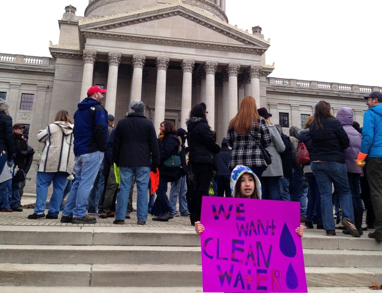 Emma Del Torto of Charleston, W.Va. holds a sign during a demonstration at the state Capitol on Saturday, Jan.18, 2014. More than 100 people gathered to question their tap water's quality following a chemical spill that tainted the local water supply. (AP Photo/John Raby)