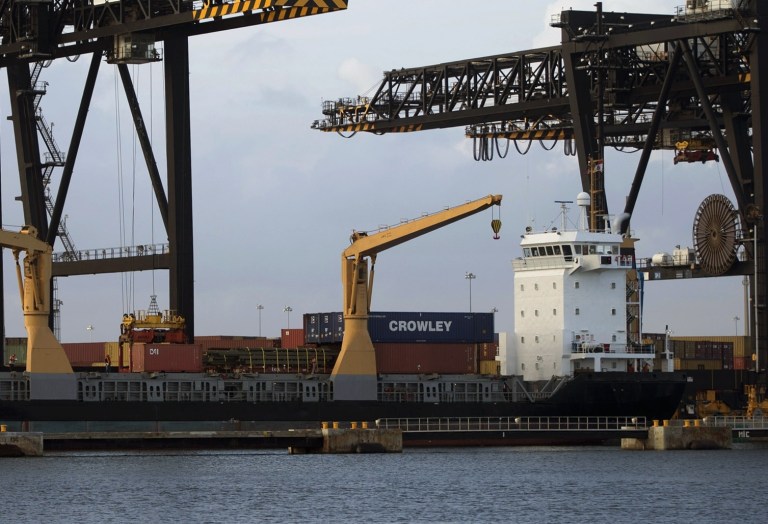 FILE - In this Jan. 8, 2013 photo, a ship is loaded with cargo in Fort Lauderdale, Fla.  The U.S. trade deficit widened only slightly in August, dragged lower by a modest decline in exports. U.S. farmers sold fewer agricultural products overseas, offsetting the best month of sales for American-made cars on record. The trade deficit grew 0.4 percent in August to $38.8 billion, the Commerce Department reported Thursday, Oct. 24, 2013. That's up from $38.6 billion in July. (AP Photo/J Pat Carter)