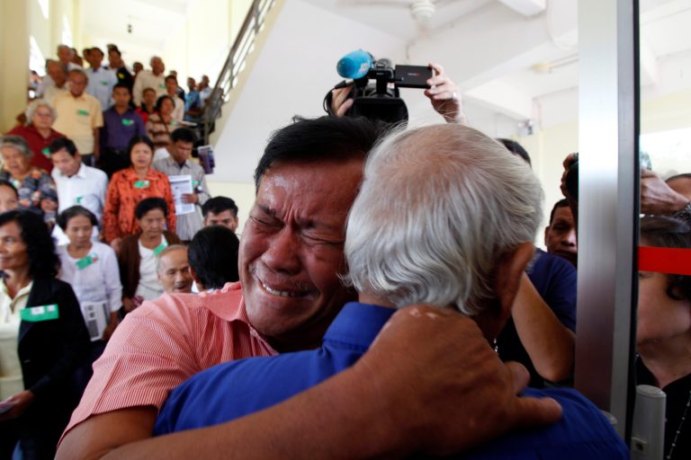 Cambodian former Khmer Rouge servitors, Soum Rithy, left, cries as he hugs Chum Mey, right, after the verdicts were announced, at the U.N.-backed war crimes tribunal in Phnom Penh, Cambodia, Thurdday, Aug. 7, 2014. Three and a half decades after the genocidal rule of Cambodia's Khmer Rouge ended, the tribunal on Thursday sentenced two top leaders of the former regime to life in prison on war crimes charges for their role in the country's terror period in the 1970s. (AP Photo/Heng Sinith)