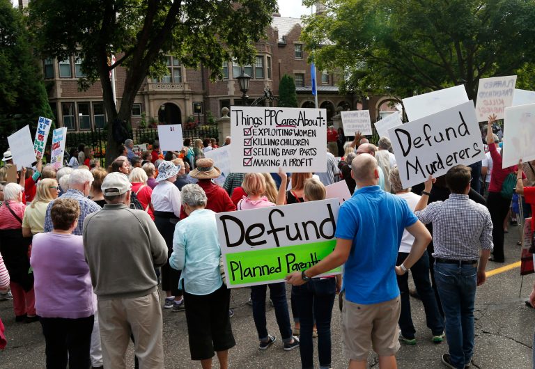 Hundreds of demonstrators gather outside the governor's mansion in St. Paul, Minn., Wednesday, Sept. 9, 2015, in a protest calling for Governor Mark Dayton to defund and investigate Planned Parenthood. St. Paul police diverted traffic to accommodate the large crowd.(AP Photo/Jim Mone)
