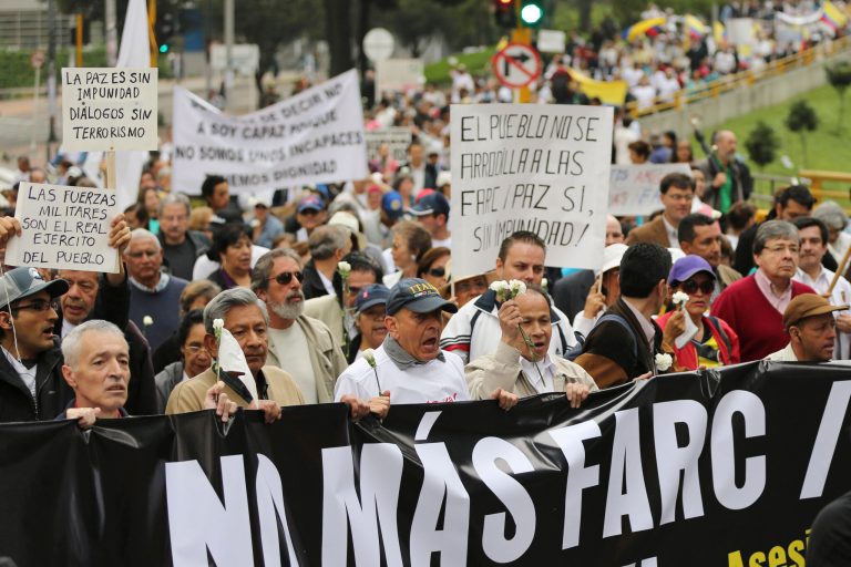 Opponents to the government's peace talks with guerrillas of the Revolutionary Armed Forces of Colombia, FARC, shout slogans an carry a banner that reads in Spanish 