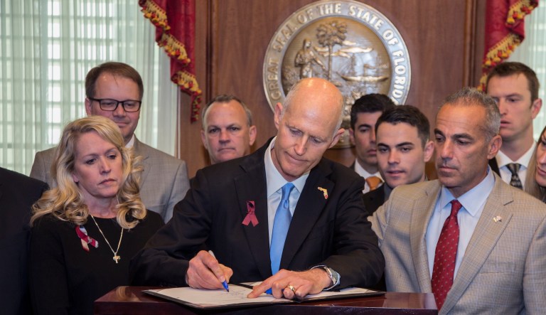 Florida Governor Rick Scott signed the Marjory Stoneman Douglas Public Safety Act Friday at the Florida Capital in Tallahassee, Fla. (AP Photo/Mark Wallheiser)