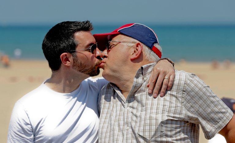 Christopher Kirbabas, left, kisses his partner David Zak, right, during marriage equality celebration event at the Kathy Osterman Beach in Chicago, Sunday, June 1, 2014. June 1 marked the first day all of Illinois' 102 counties could begin issuing marriage licenses to same-sex couples after a piecemeal start where some county officials began granting licenses months ago following a federal court ruling. (AP Photo/Kamil Krzaczynski)