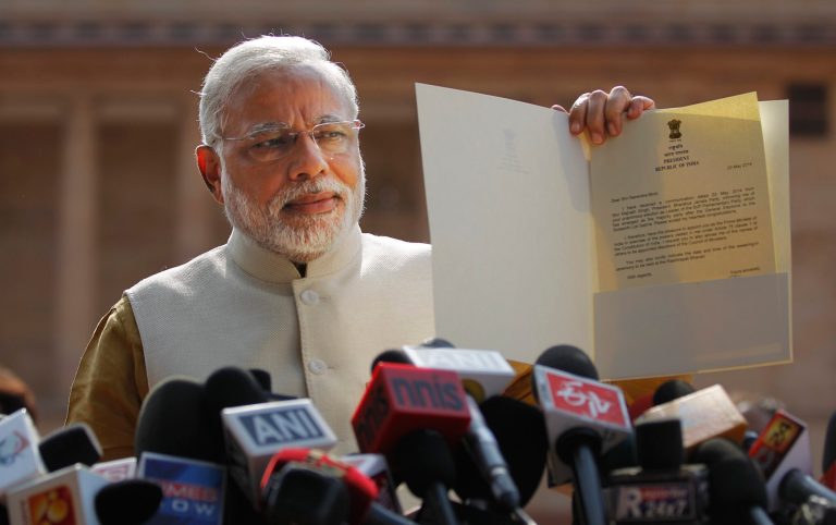 India's next prime minister and Hindu nationalist Bharatiya Janata Party (BJP) leader Narendra Modi displays the letter from the Indian President inviting him to form the new government, outside the Presidential Palace in New Delhi, India, Tuesday, May 20, 2014. Modi met with President Pranab Mukherjee after he was formally chosen by his party as the next prime minister, just days after a resounding victory in national elections. (AP Photo/Altaf Qadri)