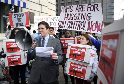 Josh Nelson, campaign manager, CREDO Mobile, center, speaks after his group was denied entrance to the Williard InterContinental Hotel where they wanted to deliver a petition to the National Rifle Association calling for the NRA to get out of the way of gun control, as the NRA is having a news conference in Washington, Friday, Dec. 21, 2012. (AP Photo/Cliff Owen)