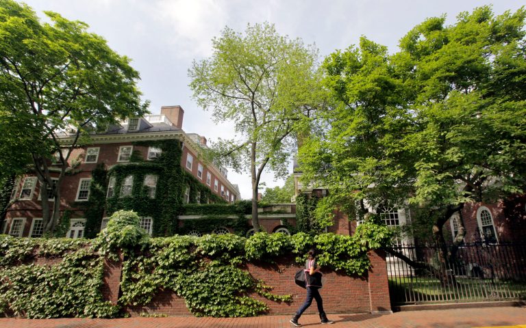 A woman walks by buildings on the campus of Harvard University in Cambridge, Mass., Wednesday, May 16, 2012. (AP Photo)Â 
