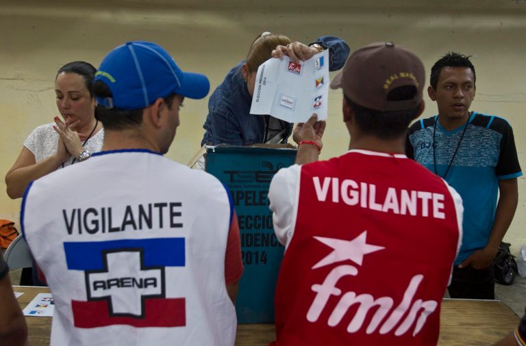 An election officer shows a ballot in front volounteers from the ruling the Farabundo Marti National Liberation Front, (FMLN) and Nationalist Republican Alliance, or ARENA, during during the vote count at a polling station in San Salvador, El Salvador, Sunday, Feb. 2, 2014. Presidential elections in two Central American countries are both referendums on political stagnation, with voters in Costa Rica deciding whether to oust the long-ruling party, and voters in El Salvador deciding whether to bring it back to power. (AP Photo/Esteban Felix)