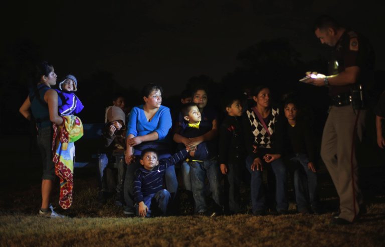 A group of immigrants from Honduras and El Salvador who crossed the U.S.-Mexico border illegally are stopped, Wednesday, June 25, 2014, in Granjeno, Texas. (AP Photo/Eric Gay)