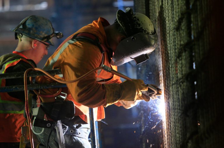 In this May 1, 2014, file photo, welders connect iron support bars.