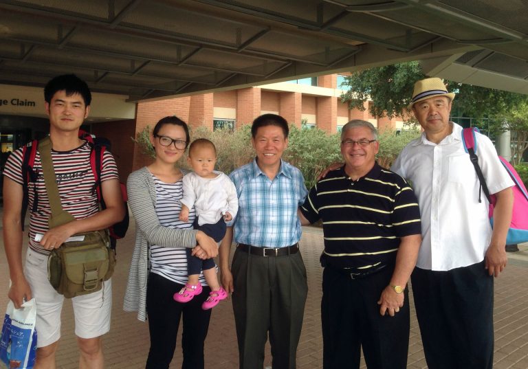 In this Tuesday, July 15, 2014 photo released by Bobfu, imprisoned Chinese pastor Zhang Shaojie's daughter Zhang Huixin, second from left, her husband Sun Zhulei, left, and their daughter Sun Jiexi take photo with church members after they arrived at the Midland International Airport in Midland, Texas. Three members of an imprisoned pastor's family have sneaked out of China to the U.S. with the help of activists after complaining about an extended campaign of harassment by Chinese authorities, a Christian rights group said Tuesday. (AP Photo/Bobfu)