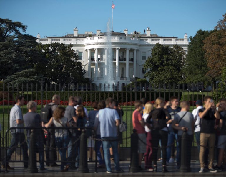 People line the iron perimeter fence that lines the South Lawn of the White House, in Washington, Monday, Sept. 22, 2014. (AP Photo/Carolyn Kaster)