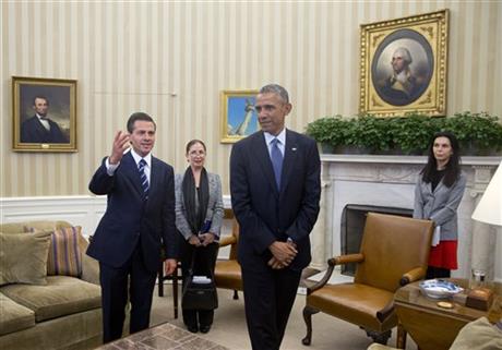 President Obama stands with Mexican President Enrique Pena Nieto in the Oval Office. AP Photo