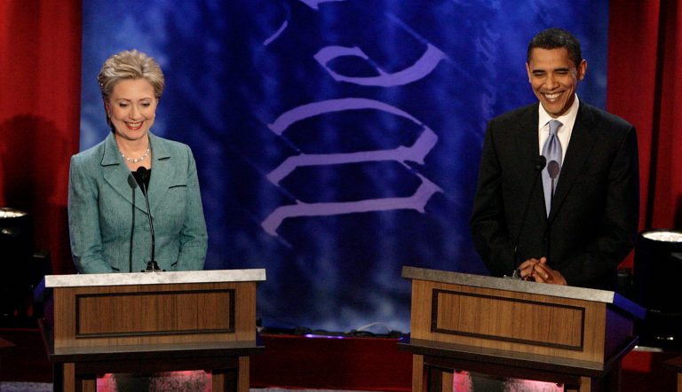 Democratic presidential hopefuls, Sen. Hillary Clinton, left, and Sen. Barack Obama smile as they stand behind the podium before a Democratic presidential debate in April 2008. (AP Photo/Jae C. Hong)