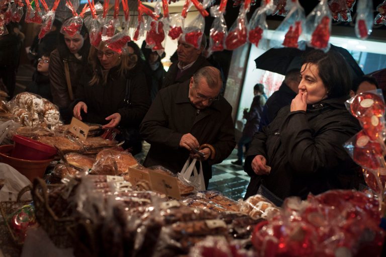 In this Monday Feb. 3, 2014 photo, people look at a stand, at a street market, in Pamplona, northern Spain. The Spanish government figures show that number of people registered as unemployed rose by 113,097 in January as temporary job contracts created over Christmas came to an end. (AP Photo/Alvaro Barrientos)