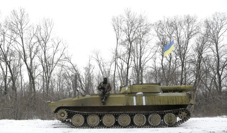An Ukrainian soldier rests on his vehicle near the road between the towns of Debaltseve and Artemivsk, Ukraine, Monday. (AP Photo/Petr David Josek)