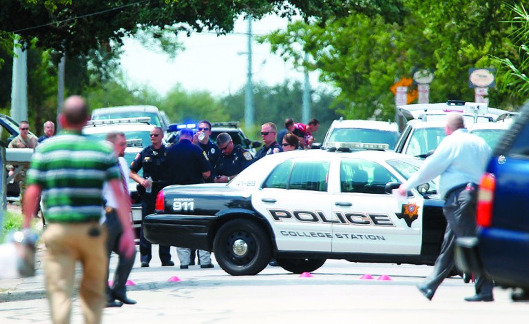 Police gather near the scene where a gunman opened fire on a police officer serving an eviction notice near the Texas A&M University on Monday, Aug. 13, 2012, in College Station, Texas. College Station Assistant Police Chief Scott McCollum says Brazos County Constable Brian Bachmann was among three people, including the gunman, killed in the shootout. (AP Photo/Houston Chronicle, Mayra Beltran) MANDATORY CREDIT: NO SALES, MAGS OUT, TV OUT, INTERNET: AP MEMBERS ONLY