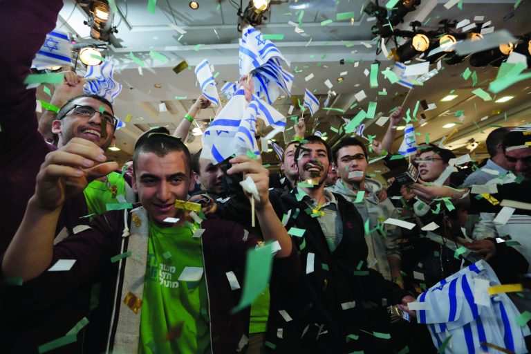 Supporters of Naftali Bennett, head of Israel's Jewish Home party celebrate after the exit polls were announced at the party's headquarters in the city of Ramat Gan, Tuesday, Jan. 22, 2013. Israeli Prime Minister Benjamin Netanyahu's Likud Party emerged as the largest faction in a hotly contested parliamentary election on Tuesday, positioning the hard-liner to serve a new term as prime minister, according to exit polls. But a lackluster performance by Likud, along with surprising gains by a centrist newcomer, raised the strong possibility that he will be forced to form a broad coalition. (AP Photo/Tsafrir Abayov)