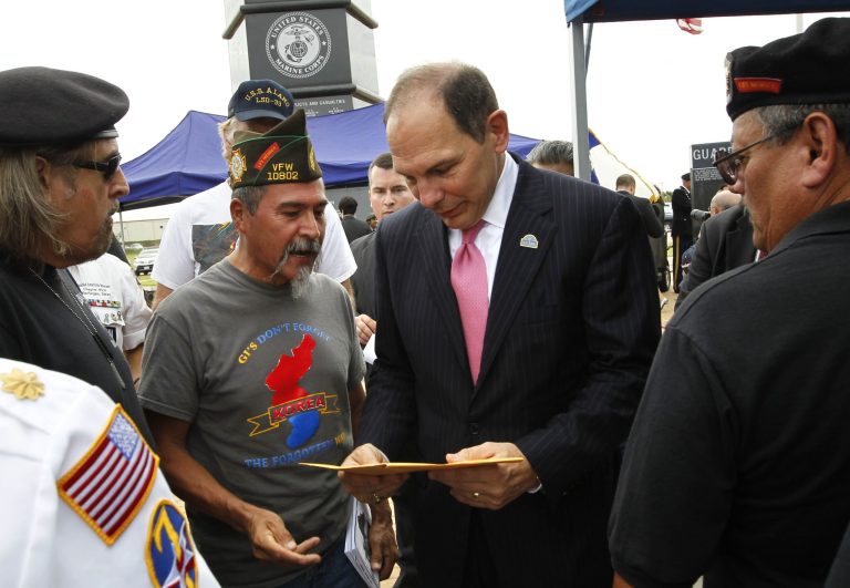 U.S. Department of Veterans Affairs Sec. Robert McDonald looks at a envelope given to him by Army veteran Victor Zavala, left, Monday Sept. 14, 2015 during a tour at the Veterans War Memorial of Texas in McAllen, Texas. (Nathan Lambrecht/The Monitor via AP)