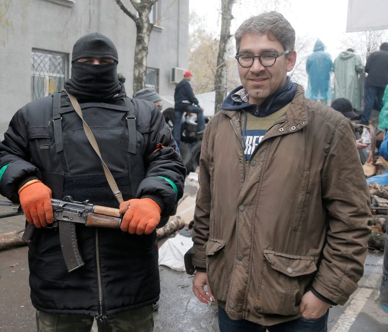 A reporter Simon Ostrovsky, right, stands next to a Pro-Russian gunman at a seized police station in the eastern Ukraine town of Slovyansk. Pro-Russian gunmen in eastern Ukraine say they are holding an American journalist captive. Ostrovsky, a journalist for Vice News, has not been seen since early Tuesday. (AP/Efrem Lukatsky)