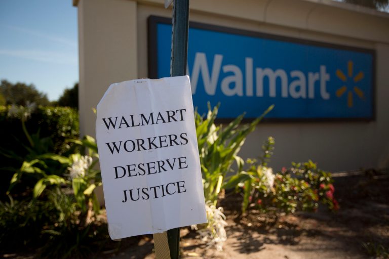A protest sign greets Black Friday shoppers at a Boynton Beach, Fla. Walmart store Friday, Nov. 28 2014. (AP Photo/J Pat Carter)
