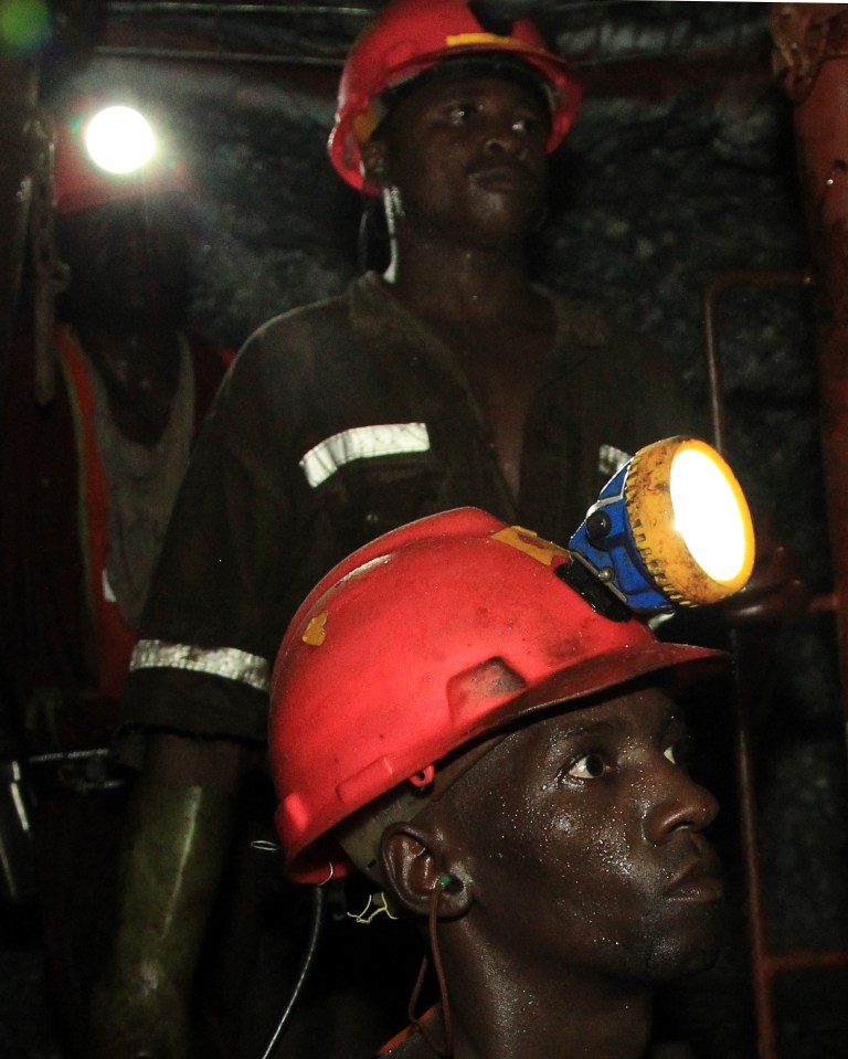 In this photo taken Thursday, Feb. 20, 2014, miners are photographed underground during a journalist's tour to the South Deep gold mine south of Johannesburg. Miners work some 2.4 kilometers  (1.5 miles) underground in 12-hour shifts, where safety is a constant concern and everyone depends on everyone else to stick to precautions.  (AP Photo/Themba Hadebe)