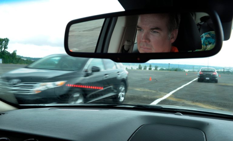   In this photo taken, Tuesday, May 22, 2012, professional test driver J.D. Ellis of Cincinnati, Ohio, demonstrates the dashboard warning signal in a Ford Taurus, at an automobile testing area in Oxon Hill, Md. The display at a recent transportation conference was a peek into the future of automotive safety: cars that to talk to each other and warn drivers of impending collisions. Later this summer, the government is launching a yearlong, real-world test involving nearly 3,000 cars, trucks and buses using volunteer drivers in Ann Arbor, Mich. (AP Photo/Susan Walsh)  
