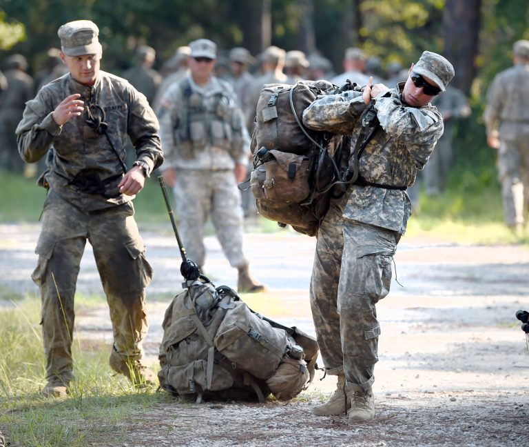 A female Army Ranger student lifts a rucksack onto her back on Tuesday, Aug. 4, 2015, at Camp James E. Rudder on Eglin Air Force Base, Fla. (Nick Tomecek/Northwest Florida Daily News via AP)
