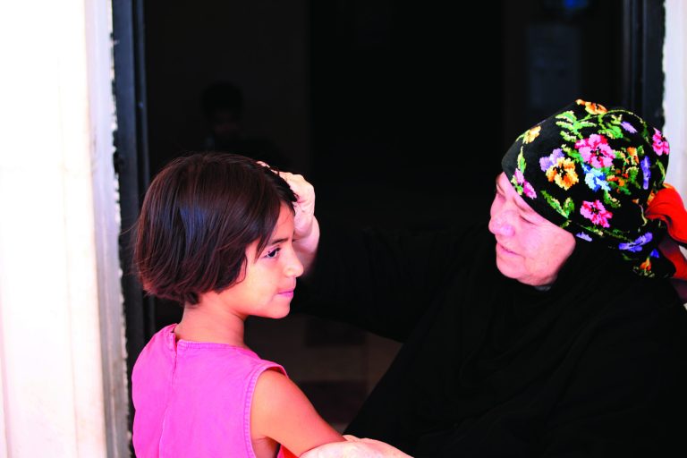 A relative of Tala Husam Qerba'a, who was wounded by Syrian artillery shells that fell near her family house, checks her wounds in Turra, Jordan, Monday, Aug. 20, 2012. Jordan's government spokesman has sternly criticized Syria for artillery shelling on its northern border that wounded a Jordanian girl and panicked other civilians. Four shells landed in Jordan on Sunday during clashes between the Syrian military and rebel forces on the Syrian side of the border. (AP Photo/Mohammad Hannon)