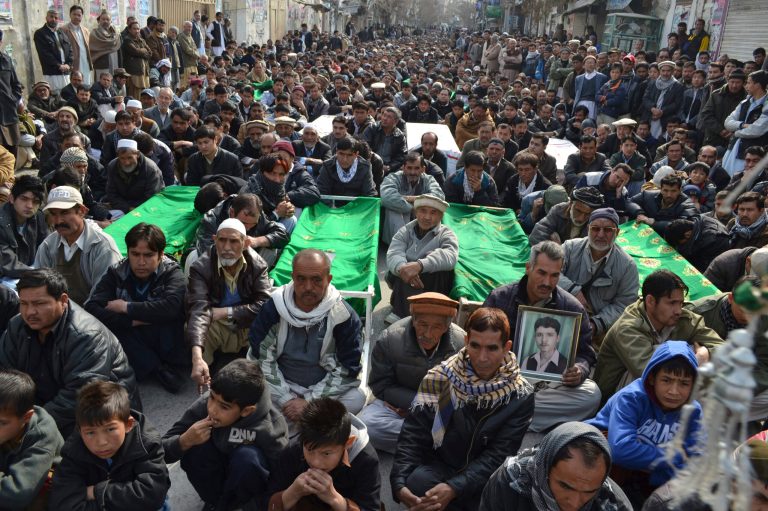 Relatives and mourners of  Shiite pilgrims who were killed on Tuesday by a bomb blast, protest sitting next to their bodies, in Quetta, Pakistan, Wednesday, Jan. 22, 2014. Shiite Muslims in Baluchistan protested Wednesday in Quetta, the capital of Baluchistan, demanding action to stop the continued violence against their sect; they brought the coffins of many of the dead into the streets as part of their protest.  (AP Photo/Arshad Butt)