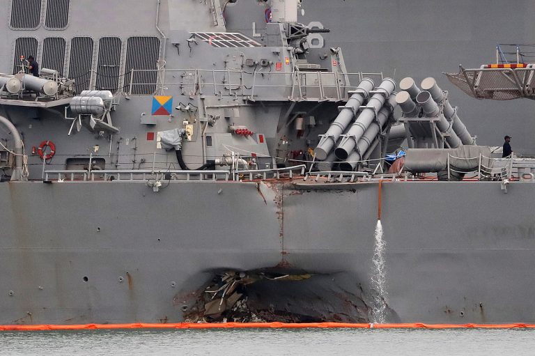FILE - In this Aug. 22, 2017 file photo. the damaged port aft hull of the USS John S. McCain is visible while docked at Singapore's Changi naval base in Singapore. Divers have recovered the remains of all 10 sailors who went missing after the USS John S. McCain and an oil tanker collided near Singapore last week, the U.S. Navy said Monday, Aug. 28, 2017. (AP Photo/Wong Maye-E, File)