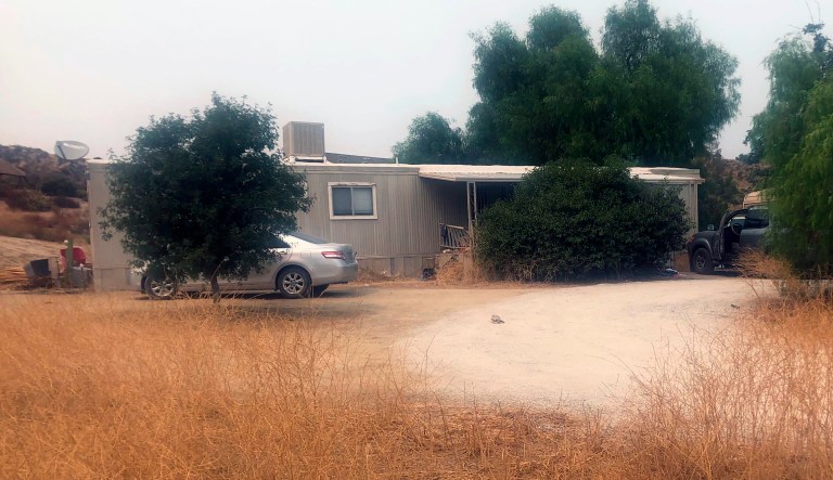 A car is left parked at a house where killings occurred in the rural town Aguanga, Calif., Tuesday, Sept. 8, 2020. Seven people were found fatally shot at an illegal marijuana growing operation in Aguanga. 