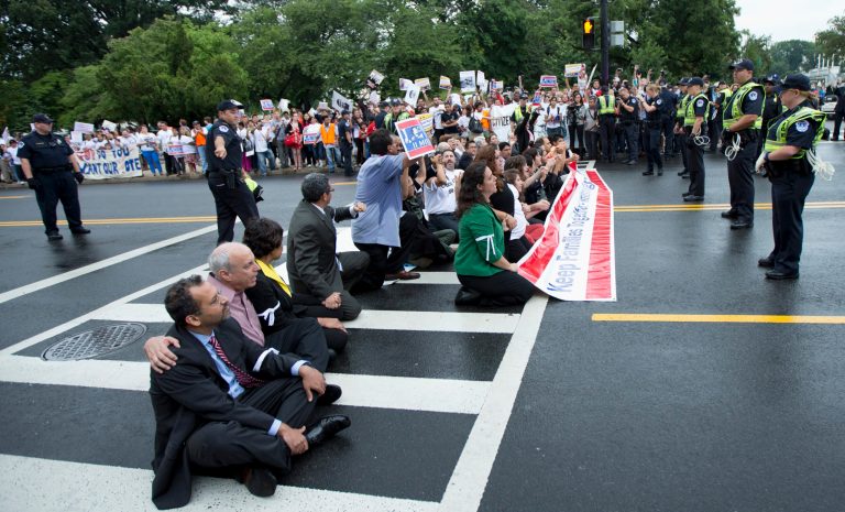   FILE - This Aug. 1, 2013 file photo shows immigration reform supporters blocking a street on Capitol Hill in Washington. For many House conservatives, President Barack Obamaâs decision to delay a central provision of his health care law has emerged as a major stumbling block _ not to health coverage, but to an immigration bill. (AP Photo/Manuel Balce Ceneta, File)  
