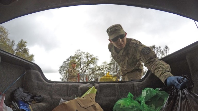 U.S. Army Sgt. Moises Castillo of the California Army National Guard helps an elder Amador County resident load food supplies into a vehicle March 23 at the Interfaith Food Bank in Jackson, California.